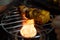 Shot of paneer cottage cheese being burnt charred tandoori grilled over a meal grill and a gas stove with flames coming