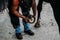 Shot of a person working with a Horse farrier, hoof and metal work to make horse shoes