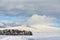 Shot of picturesque winter scenery with a cloudscape, snow-covered landscape, trees, and hills