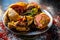 Shot of Piyaz pakora/bhaji/bhajji/bhajiya/bajji in a glass plate with some fresh green chilies and red chili powder along with it