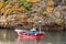 Shot of a red and blue fishing boat with a tiny Spanish flag near the cliff in Madrid, Spain