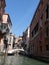 Shot of romantic side canal in Venice with gondola and  elegant buildings