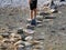 Shot of several a teenager trying to cross the pond with the help of the big stone