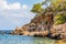 Shot of a shack  by the seaside, built under the cliff surrounded by big stone chunks