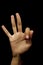 Shot of single hands doing Gyan mudra isolated on black background.