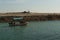 Shot of small wooden boat on blue green water clearing the inlet and going out to sea in dwarka