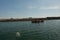 Shot of small wooden boat on blue green water clearing the inlet and going out to sea in dwarka