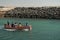 Shot of small wooden boat on blue green water clearing the inlet and going out to sea in dwarka