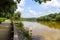 A shot of the still waters of the Chattahoochee river with lush green trees reflecting off the water with a boardwalk