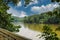 A shot of the still waters of the Chattahoochee river with lush green trees reflecting off the water with a boardwalk