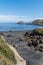 Shot of stones on the shore, the scenic waterscape of the Bay of Biscay in the background