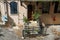 A shot of a stoop with a brown door and a black rod iron gate in front of the stairs with plants on the stoop