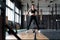 Shot of strong woman standing in crossfit gym and looking away. Confident fitness female model in sportswear.