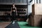 Shot of strong woman standing in crossfit gym and looking away. Confident fitness female model in sportswear.