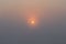 Shot of sun raising in haze over cloudless sky at early morning