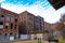 A shot of tall red brick buildings with boarded and broken windows with blue sky and clouds on the riverfront in Nashville