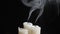 Shot of three smouldering candles on black background