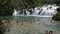 Shot of the tourists swimming in front of the waterfall in Krka national park