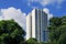 Shot of typical high rise building of public housing in Singapore, point block architecture, against blue sky with clouds. Lush