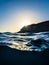 Shot from the water of the sun hiding behind the cliffs