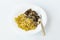 Shot on a white background. No isolation. White plate in it pasta and a piece of meat and a fork