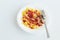 Shot on a white background. No isolation. White plate in it pasta and a piece of meat and a fork