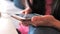 Shot of a young women hands typing something on a touchscreen of a smart phone in the living room