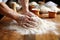 shots of hands kneading dough in a bakery, flour dusted on wooden table