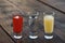 Shots with lime juice, tequila and sangria as colors of mexican flag on wooden table. Traditional serving