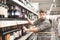 This should be fine. Side view of handsome young man holding bottle of wine and looking at it while standing in a wine store