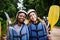 We should do this more often. Portrait of two cheerful young women wearing protective gear while holding a rowing paddle