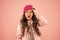 Shouting little girl pink background. kid puffer jacket and knitted hat. winter shopping. how to dress warm in winter