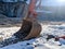 Shovel head of an excavator bulldozer laying on the ground during the winter with snow around showing the working site on hold and