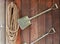Shovel and rope hanging on the wooden plank wall. Garden decoration. Gardening tools