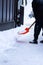 Shovel with snow in manâ€˜s hands, he is cleaning snow in the front yard of his  household