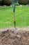 A shovel stands in a pile of mulch