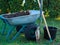 Shovel, wheelbarrow in garden grass, with bucket, gardening concept