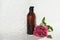 shower gel in an amber bottle with water drops. bathroom glass door and pink peony flower next to cosmetic unbranded