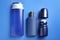 Shower gel, shampoo and roller deodorant on blue background, flat lay. Men`s cosmetics
