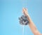 Shower, loofah and hand of woman in studio on blue background mock up. Skincare, water splash and female model holding