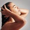 The shower revives her. Studio shot of a young woman enjoying a shower against a gray background.