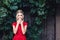 Shows shock, fright. attractive young blonde in a red dress covers her mouth with surprise.