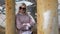 Showy woman in sweater posing among metal pillars