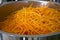 Shredded carrots in a professional large steel pan