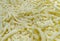 Shredded cheese background.Heap of Grated pizza cheese close up texture