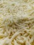 Shredded cheese background.Heap of Grated pizza cheese close up texture