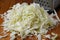Shredded white cabbage on the table next to the grater