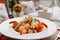 Shrimp appetizer, light summer dish on table oudoors, toned