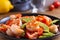 Shrimp, Avocado, Tomato and Cilantro Salad. Grilled prawns on black plate.