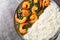 Shrimp curry cooked in a spinach, cream, spices, tomato, and ginger served with rice closeup on the plate. Horizontal top view